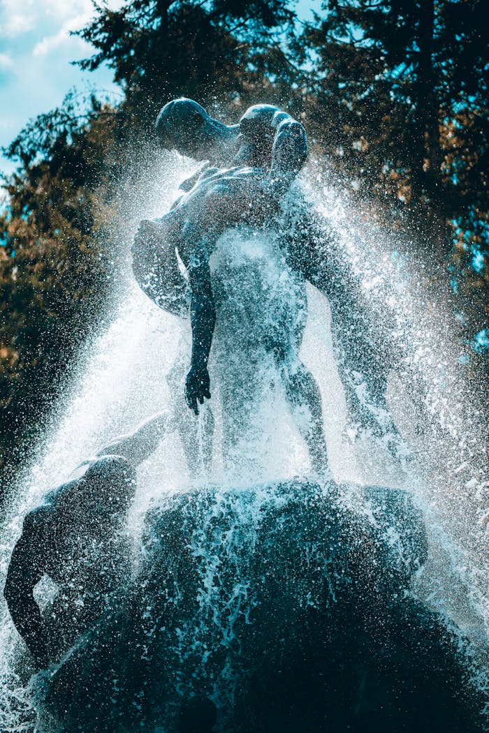 A powerful sculpture against a forest backdrop with cascading water creating a dramatic effect.