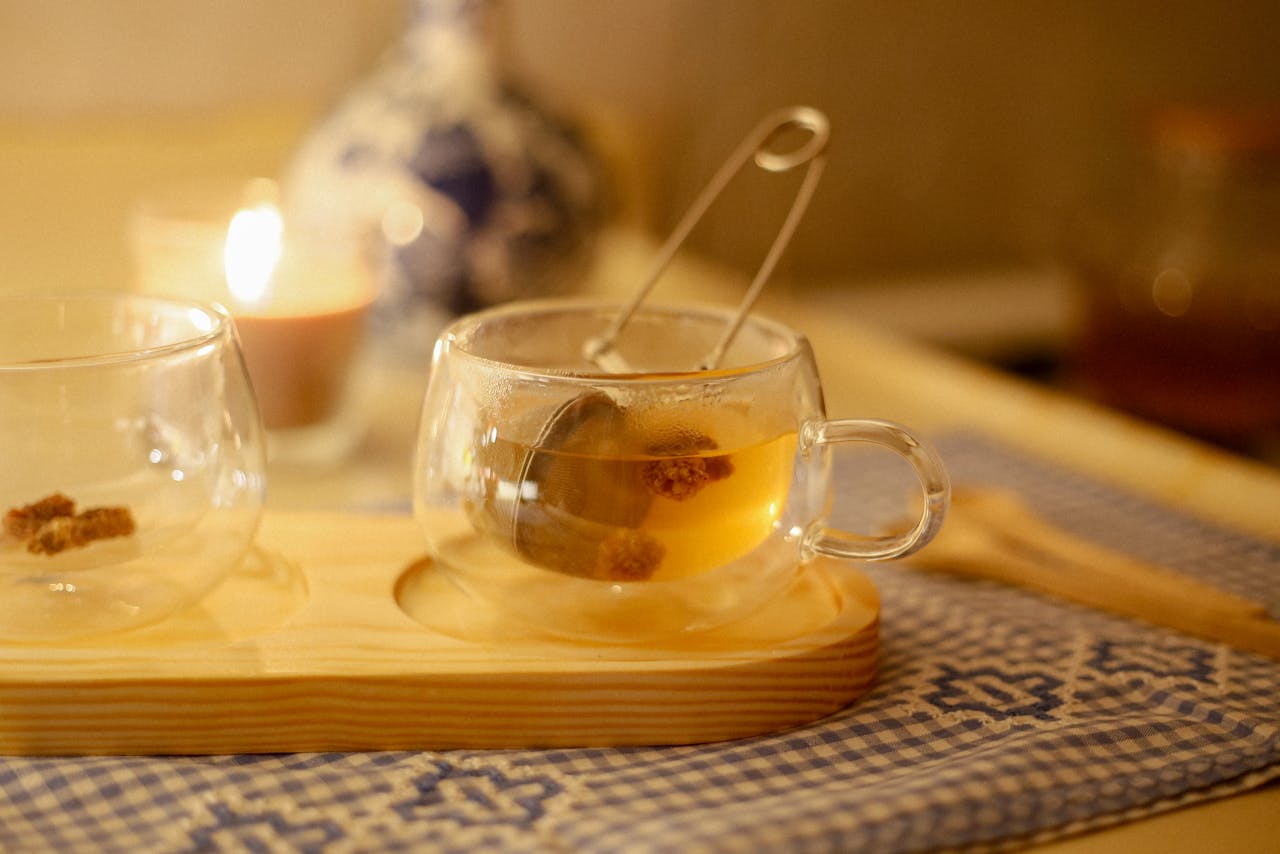 A cozy tea arrangement with a burning candle, perfect for a relaxed evening atmosphere.